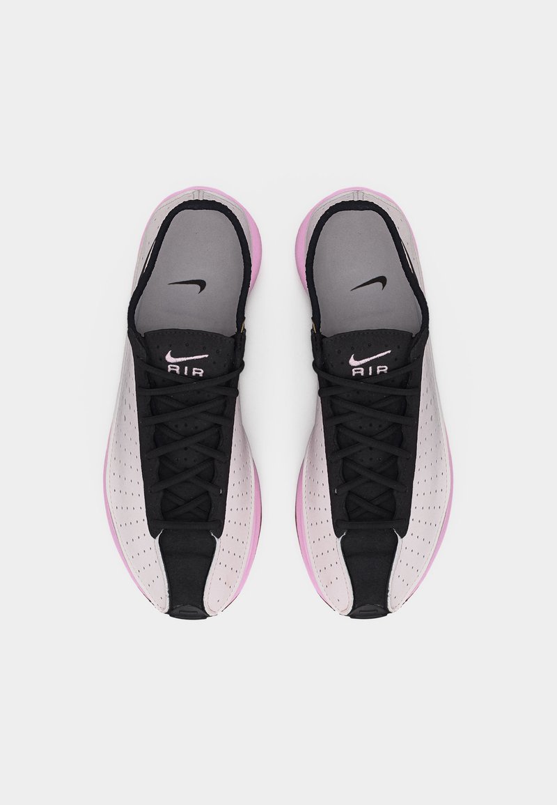 Een paar roze en zwarte Nike Air sneakers gezien van boven, met zwarte veters en geperforeerde zijpanelen.