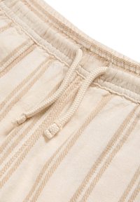 Shorts en coton avec cordon de serrage, présentant des rayures beige clair et crème, avec un tissu texturé et une fermeture en cordon tressé.