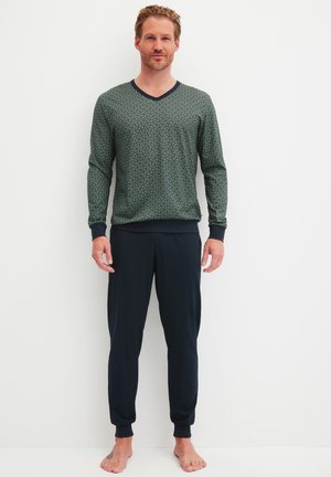Heren loungewear set: groene gebloemde V-hals langwerpige top met marineblauwe manchetten, gecombineerd met marineblauwe joggerbroeken met enkelmanchetten.