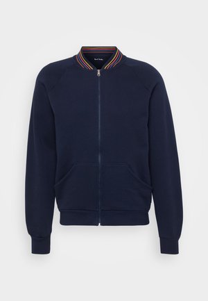 Sweatshirt azul-marinho com fecho éclair e colarinho canelado, apresentando riscas multicoloridas, dois bolsos frontais e punhos e bainha canelados.