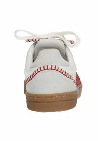 Basket en daim blanc avec des coutures et des accents rouges, bout rond, profil bas et semelle en caoutchouc beige ; dotée d'un système de laçage et d'un talon texturé.