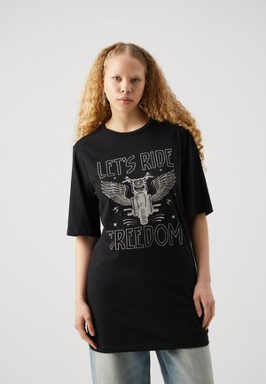T-shirt noir surdimensionné à manches courtes. Présente un imprimé graphique d'une moto avec des ailes et le texte "LAISSONS ROLLER LA LIBERTÉ" en blanc.