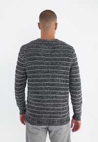 Gestrickter Pullover in Dunkelgrau mit weißen Streifen, mit Rundhalsausschnitt, gerippten Bündchen und strukturierter Oberfläche. Standard-Fit-Design.