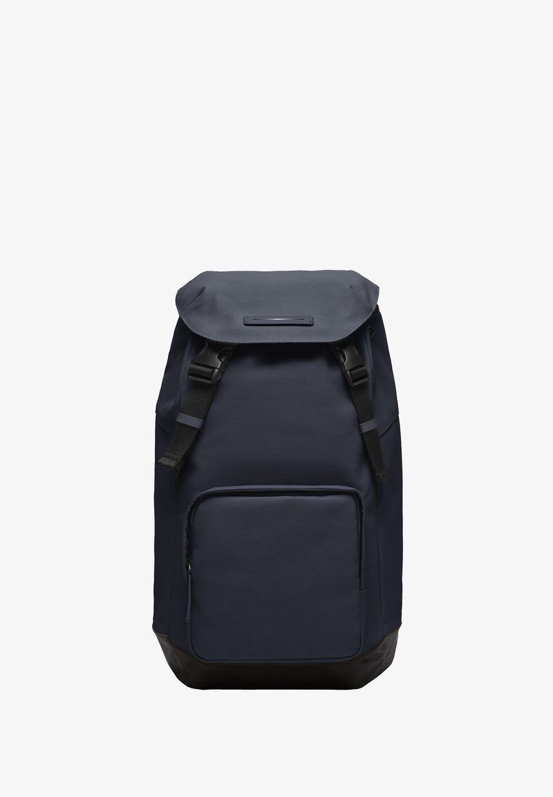 Un sac à dos bleu marine avec une finition texturée, un rouleau supérieur, des bretelles réglables, une poche zippée à l'avant et une partie inférieure noire renforcée.