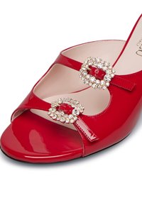 Scarpa con tacco a wedge aperta davanti in vernice rossa, caratterizzata da due fibbie decorate con strass trasparenti e una fodera interna liscia.