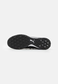Black and white athletic shoe sole, featuring a textured rubber surface with circular and hexagonal patterns for traction. PUMA logo embossed.