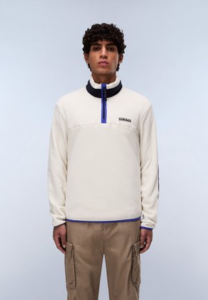 Fleece pullover in cream with a navy collar, half-zip closure, and blue accents. Features logo on the chest and ribbed cuffs.