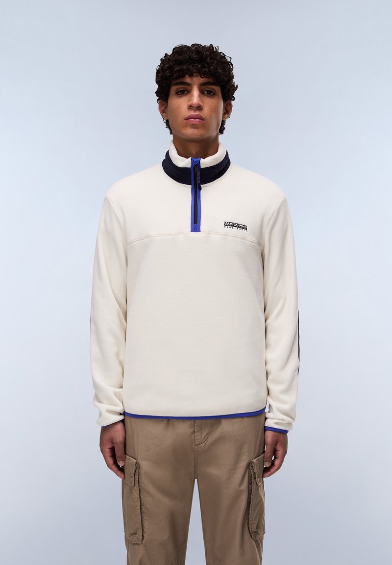 Fleece pullover in cream with a navy collar, half-zip closure, and blue accents. Features logo on the chest and ribbed cuffs.