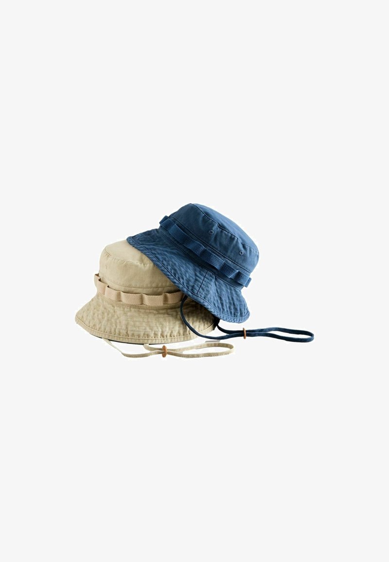 Deux chapeaux bob en coton, un beige et un bleu, chacun avec des lanières sous le menton et des détails de bande cousue, empilés sur un fond blanc.