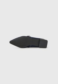 Tacco in camoscio blu navy con punta affusolata, suola in gomma nera e dettagli minimal. Presenta una cinghia per una vestibilità sicura sul piede.