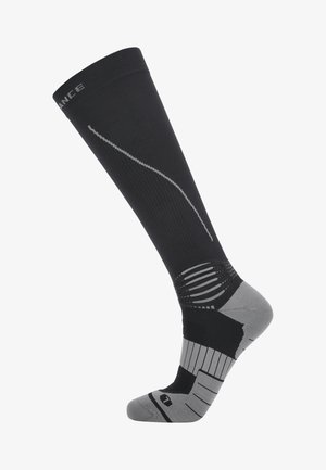 Chaussette de compression noire et grise montant jusqu'au genou, avec soutien de la voûte plantaire côtelé et rembourrage au talon et aux orteils.