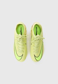Botas de fútbol de color verde lima con acentos y cordones negros. Presentan un upper texturizado y un diseño aerodinámico y elegante. Ligeras, con un patrón vibrante.