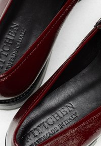 Bordeaux patentleren dameschoenen met een gladde textuur, iets afgeronde neus en subtiele branding op de zwarte binnenzool.