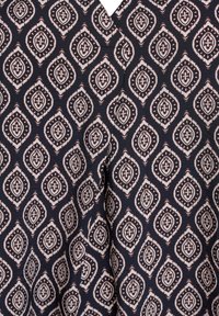 Blauer Stoff mit einem sich wiederholenden Muster aus weißen und burgunderfarbenen Rauteformen, mit aufwendigen Details und weicher Textur.