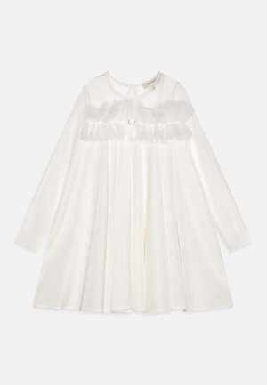 Hvid kjole med lange ærmer, gennemsigtig overlay, folderet liv og en rund halsudskæring. Har en dekorativ knap i taljen. Glat tekstur.