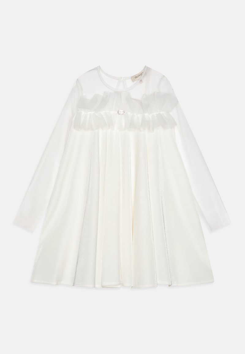 Robe blanche à manches longues, superposition transparente, corsage froncé et col rond. Présente un bouton décoratif à la taille. Texture lisse.