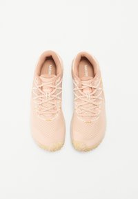 Zapatillas deportivas de color rosa claro con parte superior de malla, suela de goma texturizada y cordones blancos en contraste. Presenta un sutil logotipo en la lengüeta.