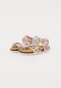 Floral sandals with a white base, featuring pink, yellow, and blue flowers. Straps are secured with silver buckles; cork insole with white outsole.