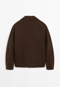 Brun uldjakke med krave, lange ærmer og knappede manchetter. Har en rygslids og et rent, minimalistisk design.