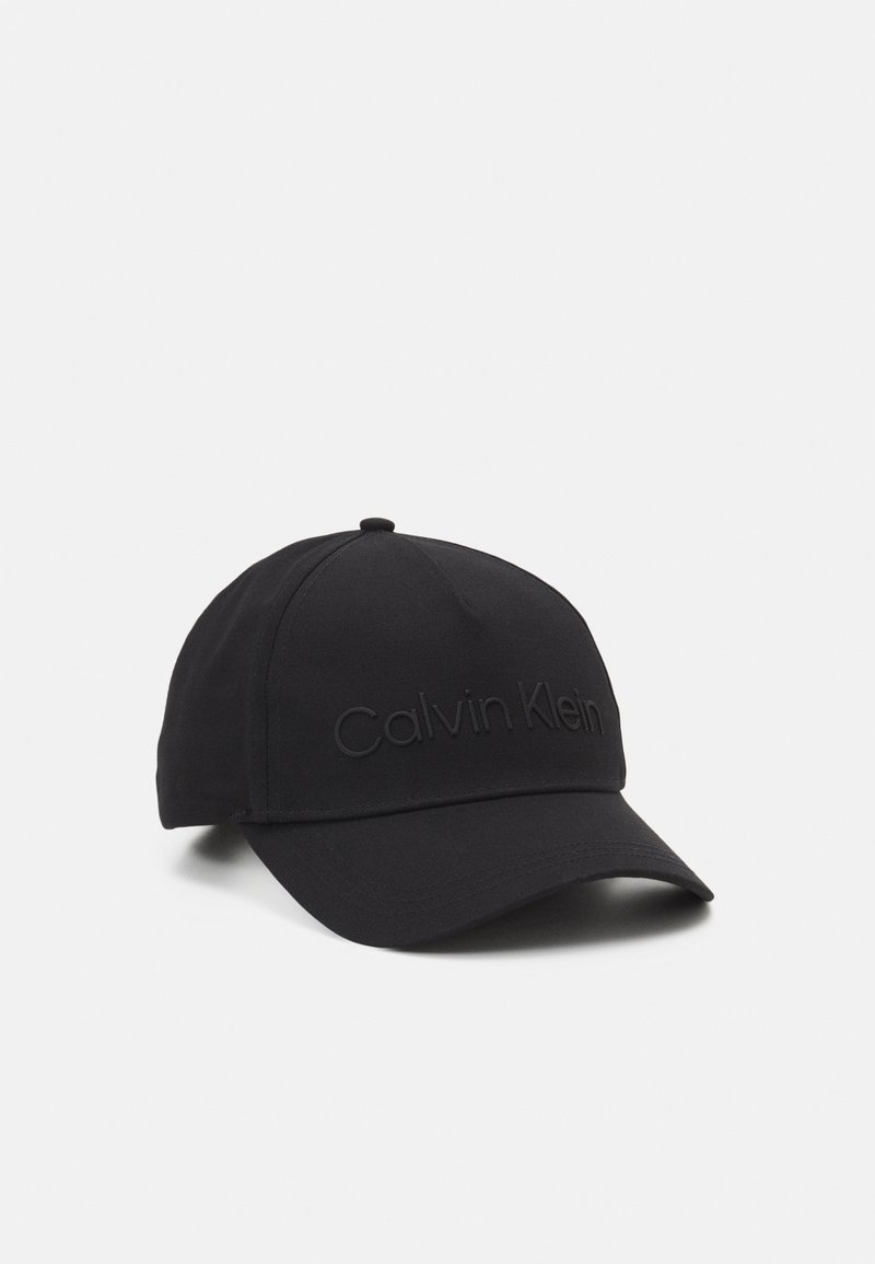Casquette de baseball noire avec une visière incurvée et le logo Calvin Klein en relief sur le devant, présentée sur un fond blanc uni.