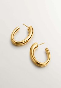 Pendientes de aro de metal dorado con un diseño liso y redondeado. Cada pendiente presenta un acabado pulido y sencillo, además de un cierre de tipo stud con pasador seguro.