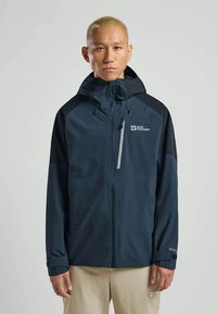 Laadukas tummansininen vesitiivis takki, jossa on etuvetoketju, huppu ja kontrastiväri mustat hihat. Varustettu logolla, säädettävillä hihansuilla ja hengittävällä kankaalla.