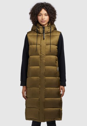 Lange olijfgroene puffer vest met capuchon, voorzien van een gewatteerd ontwerp, een rits aan de voorkant en verstelbare trekkoorden. Zwarte mouwen zichtbaar eronder.