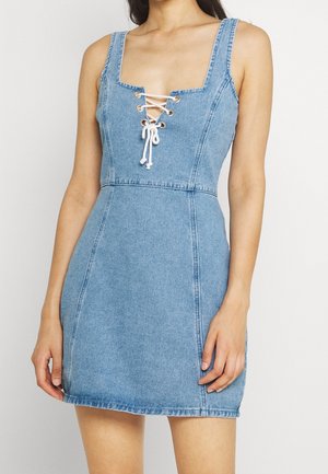 Blå denimklänning med fyrkantig halsringning, snörning framtill med vit snöre, och en figurnära passform med utsvängd fåll.