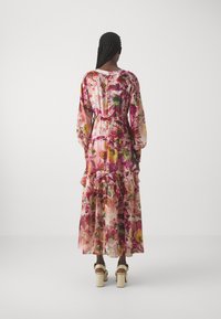 Floral maxi-jurk met lange mouwen, gerimpelde zoom en een ceintuur om de taille. Heeft roze en meerkleurige bloemenpatronen op een lichtgewicht stof.