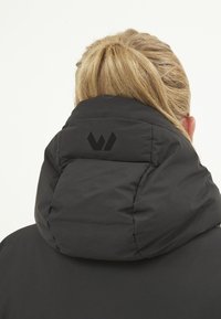 Doudoune noire avec un col montant et un logo noir au dos. Texture lisse, design chaud, adaptée aux temps froids.