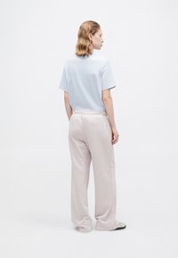 Lyseblå kortærmet T-shirt i kombination med bløde, blege rosa sweatpants med løs pasform og elastisk talje. Minimalistisk design.