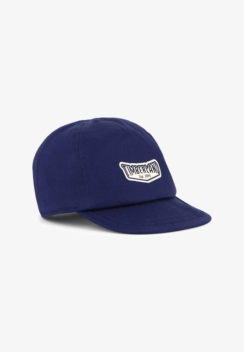 Casquette de baseball bleu marine en coton, avec un écusson blanc "Timberland" sur le devant. Couronne arrondie et visière rigide.