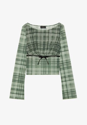 Top court en carreaux verts avec des manches longues, présentant un col froncé et un accent à nouer noir à la taille. Fabriqué en tissu léger.