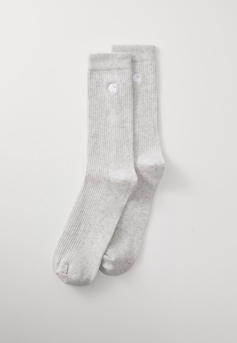 Chaussettes côtelées grises en tissu doux, avec un accent logo subtil. Le design comprend une longueur standard avec un renforcement au niveau des orteils et du talon.