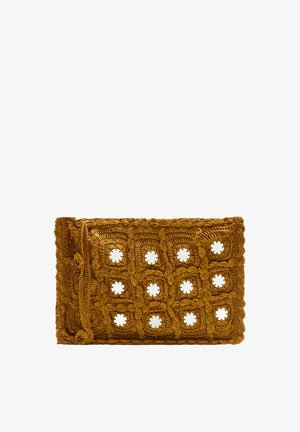Szydełkowa torebka kopertówka w musztardowym odcieniu, z okrągłymi wycięciami i teksturowanym wykończeniem, z zawiązanym zapięciem z jednej strony.