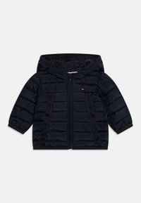 Chaqueta de plumas azul marino con capucha, que presenta un textura acolchada, cierre frontal con cremallera y franjas decorativas negras a lo largo de los lados.
