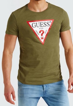 Olivengrøn kortærmet t-shirt med en rød trekantet "GUESS"-logo og hvid tekst, med en glat tekstur og tætsiddende pasform.