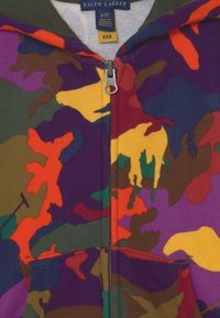 Bluza z kapturem zapinana na zamek, z wielokolorowym wzorem kamuflażu w odcieniach fioletu, pomarańczu, żółci, brązu i zieleni; wykonana z miękkiego materiału, z kieszeniami z przodu.