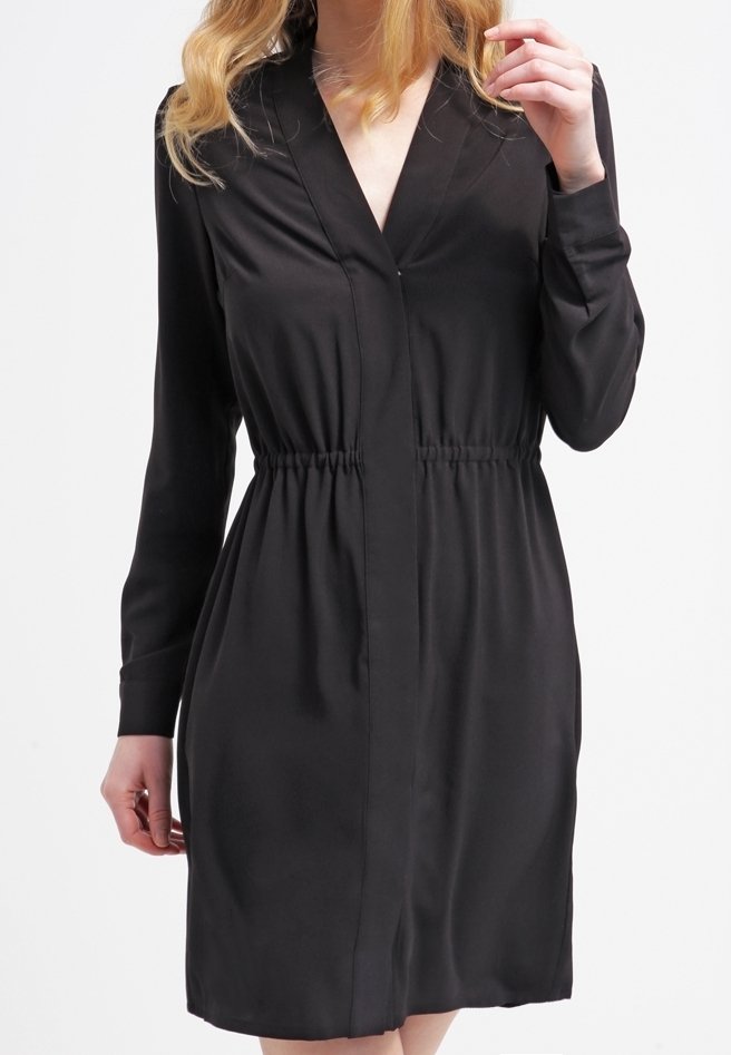 Svart klänning med V-hals, långa ärmar och elastisk midja. Slät tyg med midi-längd, med en enkel design och inga mönster.