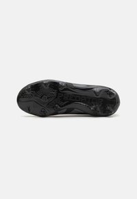 Suela de zapato deportivo negra con patrón texturizado, que presenta tacos moldeados para el agarre. Nombre de la marca "PREDATOR" grabado en el lateral.