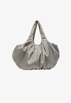 Grand sac à main en tissu souple avec un petit motif à carreaux beige et marron, poignées rembourrées, et un logo rond bleu en bas à droite.