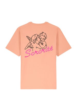 T-shirt color pesca chiaro con un disegno a linea nera che raffigura due cherubini che si abbracciano, con la parola "Sororità" in corsivo rosa in grassetto sottostante.