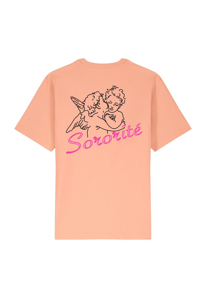 Gaišs persiku krāsas t-krekls, kurā redzams melns kontūrzīmējums ar diviem eņģelīšiem, kas apskauj viens otru, un zem tā burtiski rozā slīpā fontā rakstīts "Sororité".