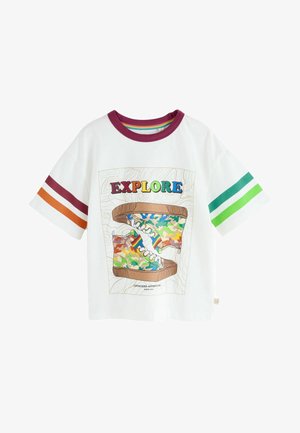 Camiseta blanca de algodón con mangas cortas, que presenta un gráfico de zapatilla colorido y el texto "EXPLORA". Acentuada con mangas a rayas en naranja y verde.