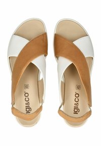 Sandały s křížovými pásky vyrobené z hnědé kůže a bílé syntetické látky. Zaoblený tvar s měkkou texturovanou stélkou a světlou podrážkou.