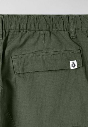 Groene shorts met een elastische tailleband, een achterzak en een klein merkembleem. De stof heeft een gladde, lichte textuur.