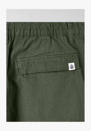 Groene shorts met een elastische tailleband, een achterzak en een klein merkembleem. De stof heeft een gladde, lichte textuur.