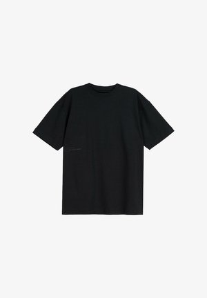Czarny, krótki rękaw, bawełniany T-shirt z okrągłym dekoltem i luźnym krojem, ułożony płasko na białym tle.