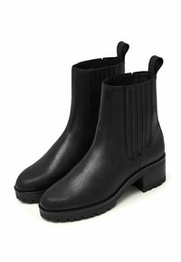 Ett par svarta läderankleboots med klossklackar, elastiska sidopaneler, dragflikar och robusta sula.
