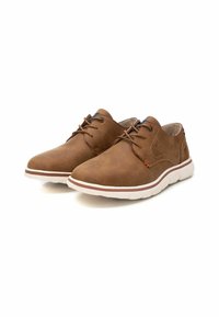 Zapatos de cuero marrón con un diseño elegante, que cuentan con cordones, una suela blanca y sutiles acentos de costura. Textura suave con punteras redondeadas.